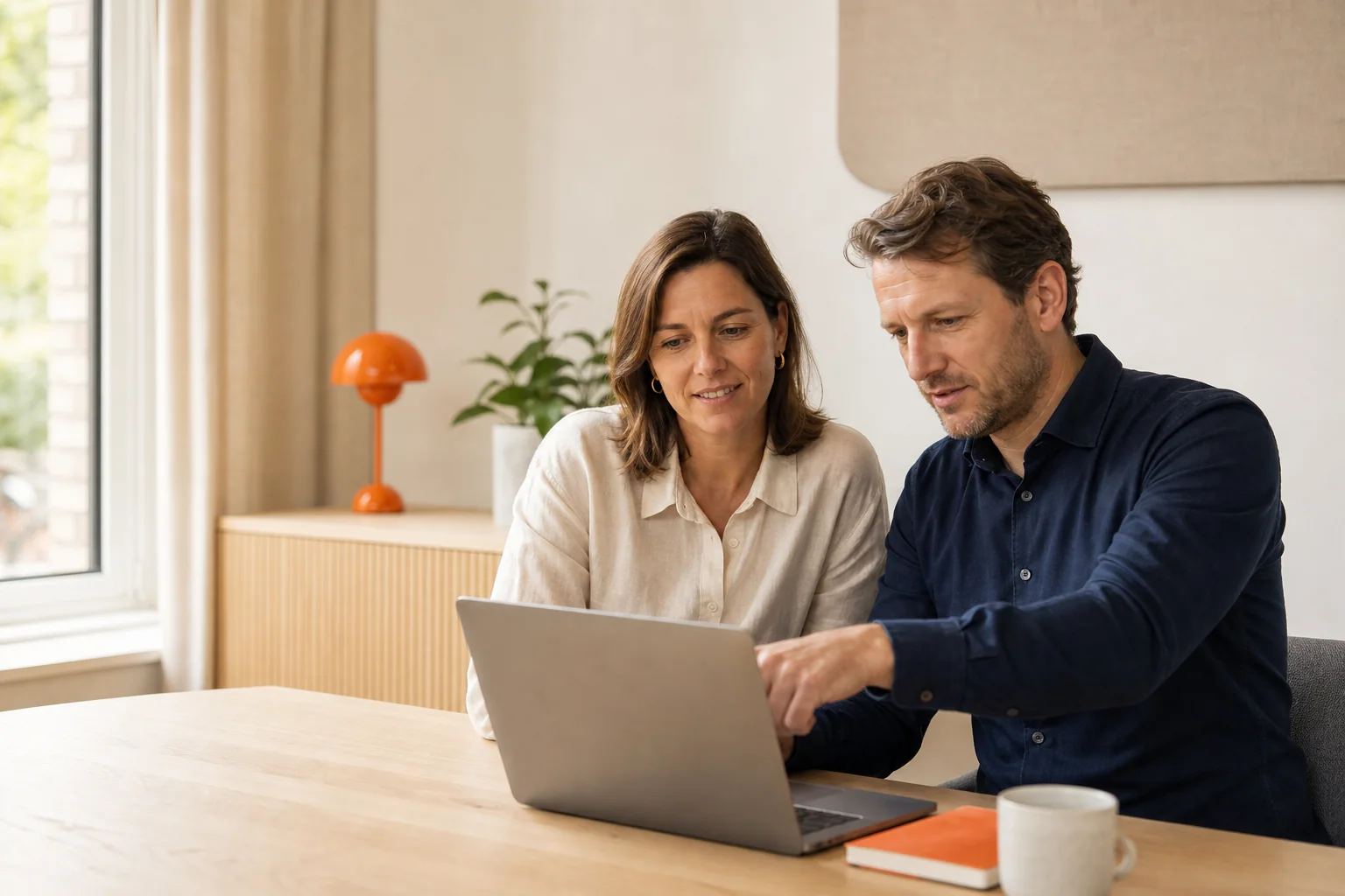 Twee ondernemers bekijken samen hun website op een laptop.